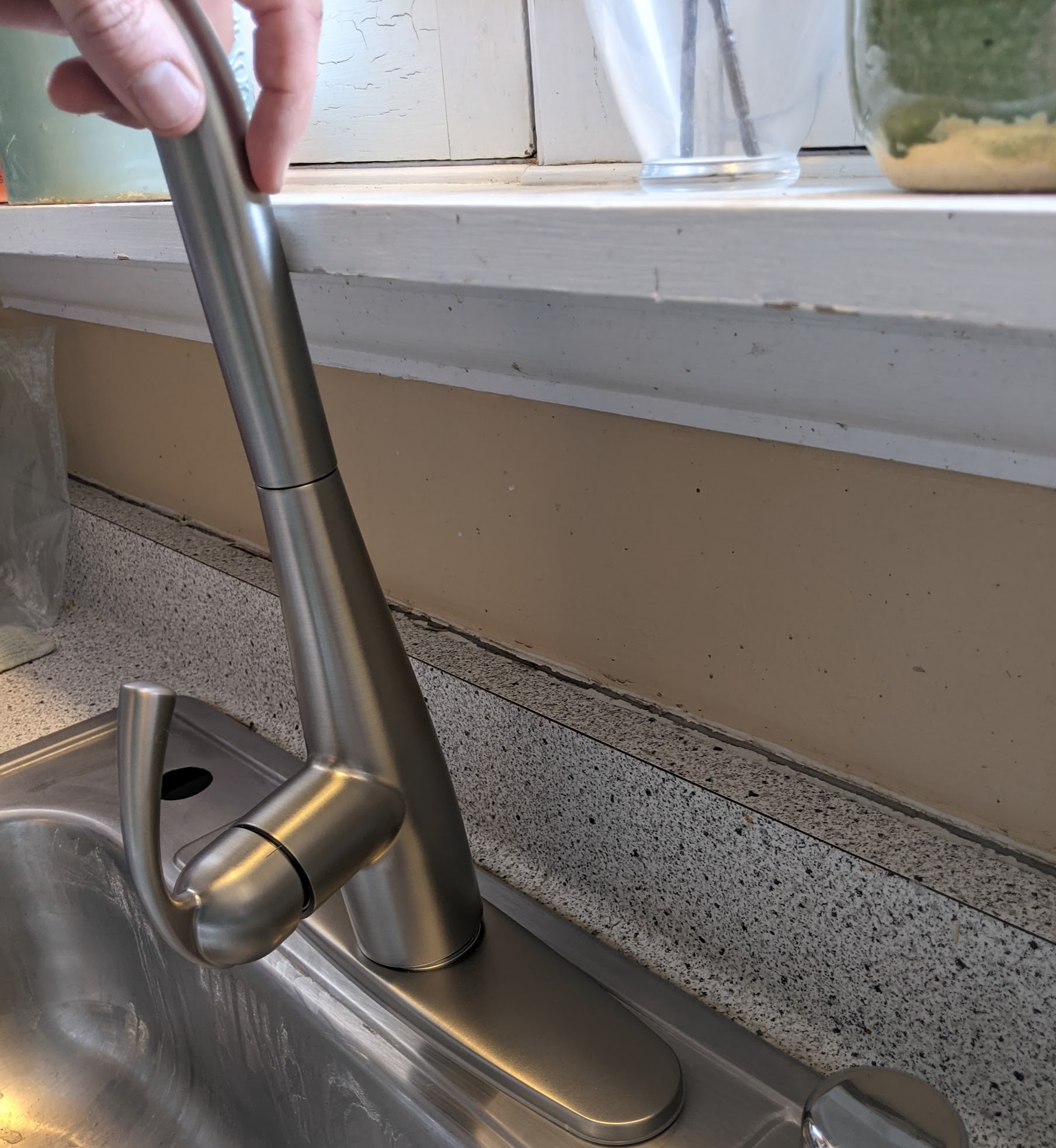 A kitchen faucet unable to be installed, due to a shelf obstructing it.